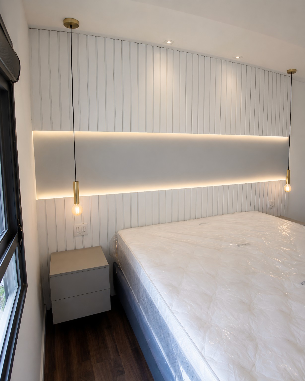 Cabeceira branca ripada com painel central e iluminação indireta em LED