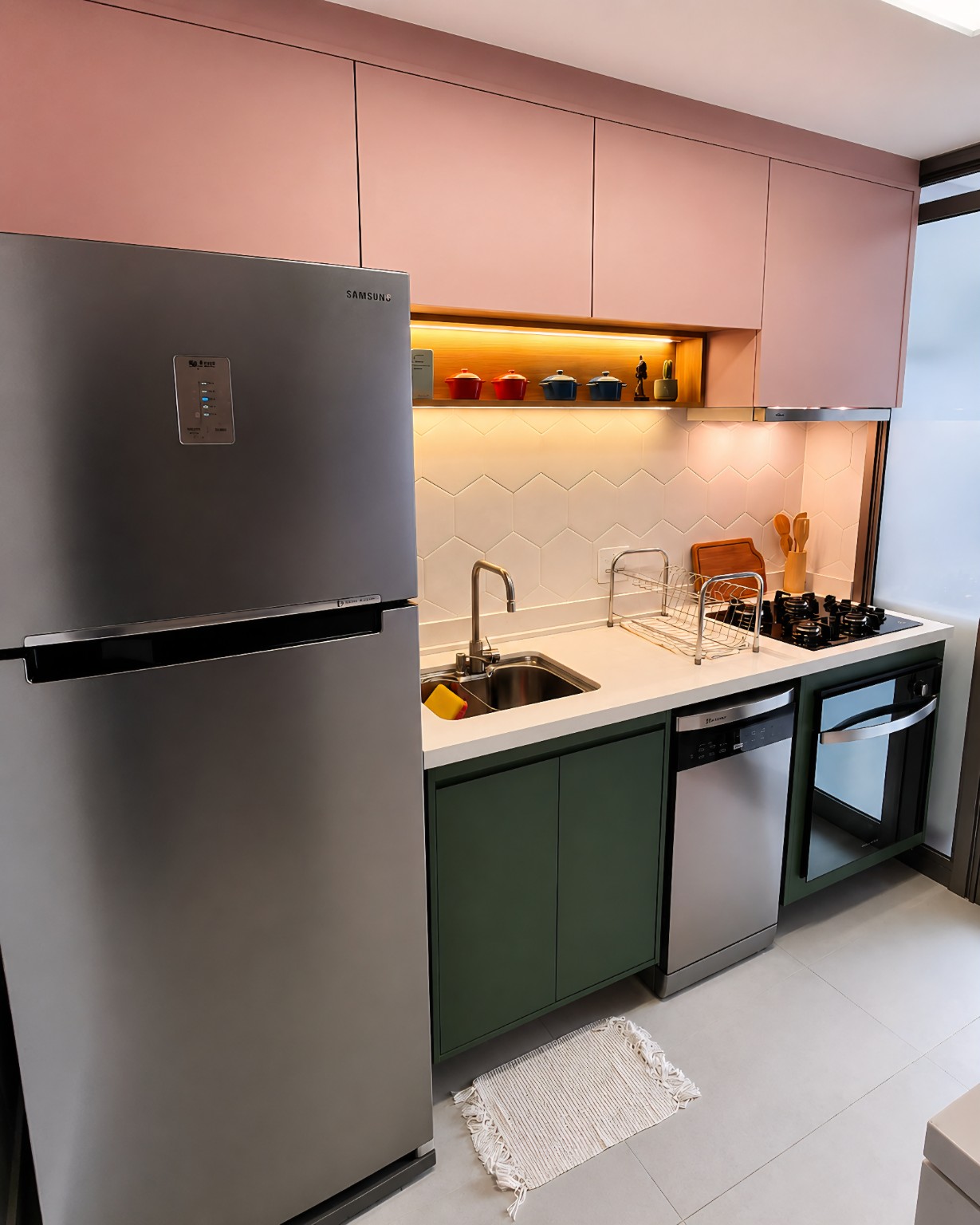 Cozinha planejada rosa e verde com nicho amadeirado iluminado